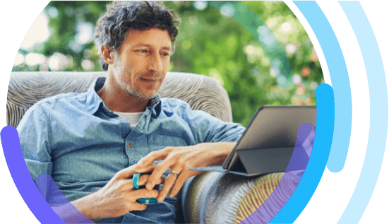 Image of a man sitting on sofa looking at digital tablet